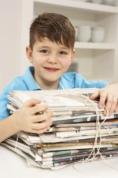 年轻的男孩回收利用报纸在家里 — 图库照片
