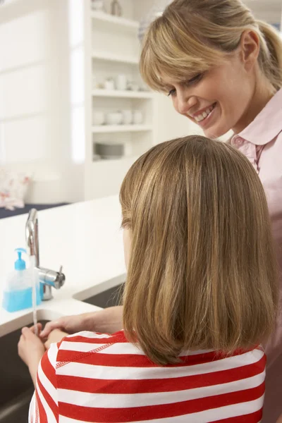 Moeder en dochter wassen handen in kitchen sink — Stockfoto