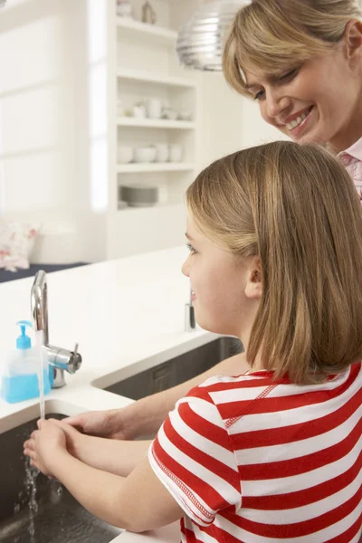 Mãe e filha lavar as mãos na pia da cozinha — Fotografia de Stock
