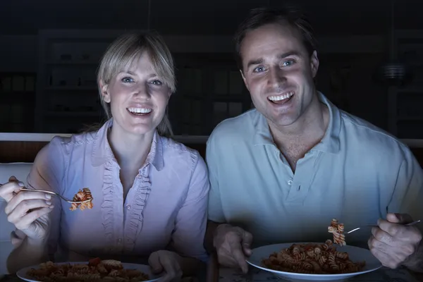Casal desfrutando de refeição enquanto assiste TV — Fotografia de Stock