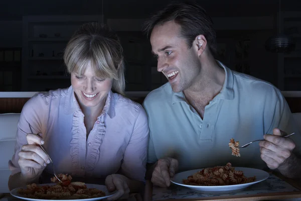 Пара насолоджуючись їжею під час перегляду телевізора — стокове фото