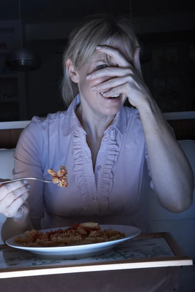 Vyděšená žena užívat jídlo při sledování tv — Stock fotografie