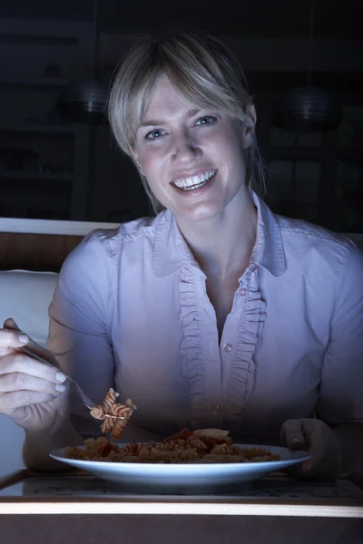 Kvinna njuter måltid medan du ser tv — Stockfoto