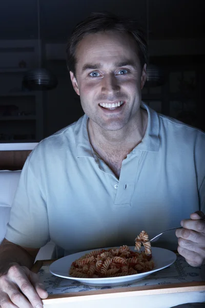 Hombre disfrutando de la comida mientras ve la televisión — Foto de Stock