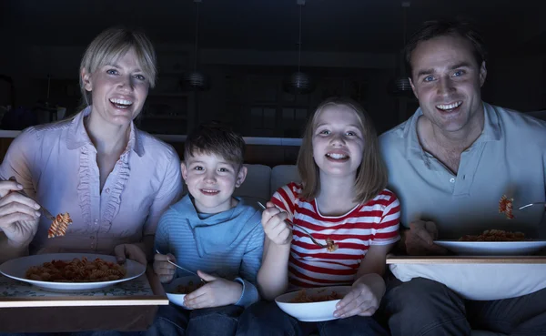 Familia disfrutando de la comida mientras ve la televisión —  Fotos de Stock
