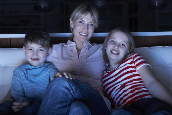 Matka a děti sledovat program v televizi, sedí na pohovce tog — Stock fotografie