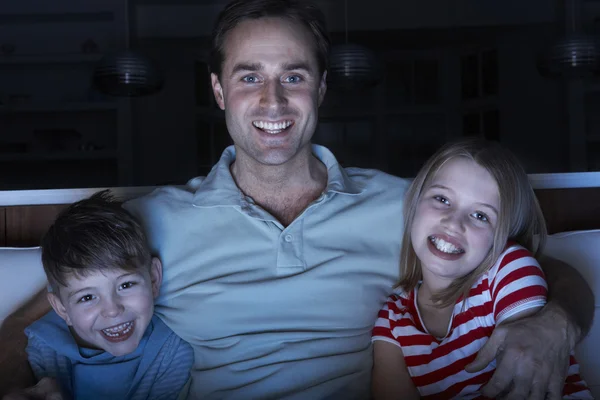 Otec i děti sledovat program v televizi, sedí na pohovce tog — Stock fotografie