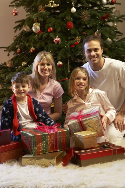 Rodina otevírání vánoční dárek před strom — Stock fotografie