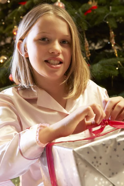 Menina Abertura Presente de Natal na frente da árvore — Fotografia de Stock