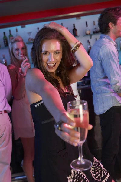 Νεαρή γυναίκα, διασκεδάζοντας σε πολυσύχναστο μπαρ — Φωτογραφία Αρχείου