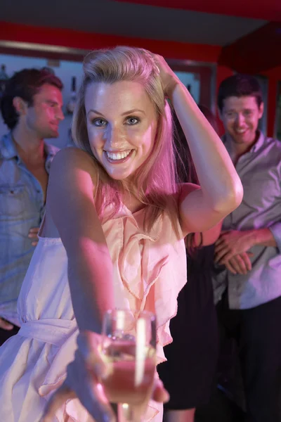 Молодая женщина развлекается в оживленном баре — стоковое фото