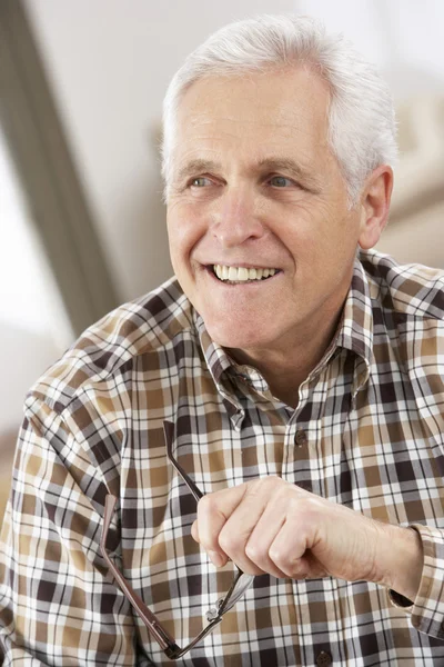 Hombre mayor con gafas relajante en silla en casa —  Fotos de Stock