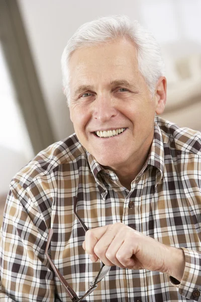 Senior man met bril ontspannen in stoel thuis — Stockfoto