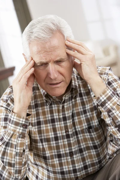 Uomo anziano guardando stressato in sedia a casa — Foto Stock