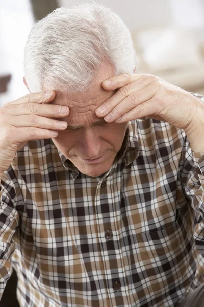 Hombre mayor mirando estresado en silla en casa —  Fotos de Stock