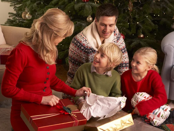 家族が自宅のクリスマスのギフトを開く — ストック写真