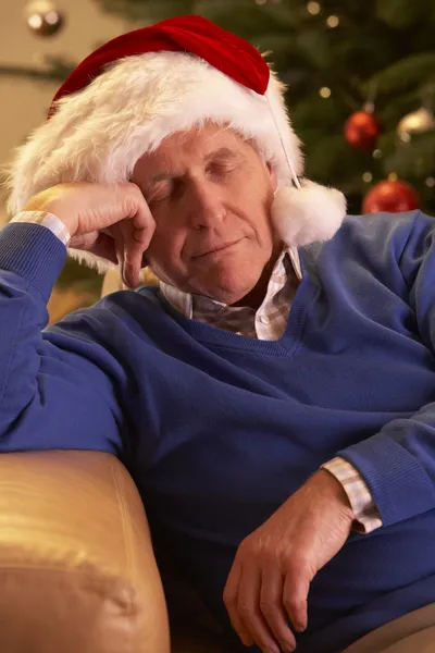 Uomo anziano stanco rilassarsi davanti all'albero di Natale — Foto Stock