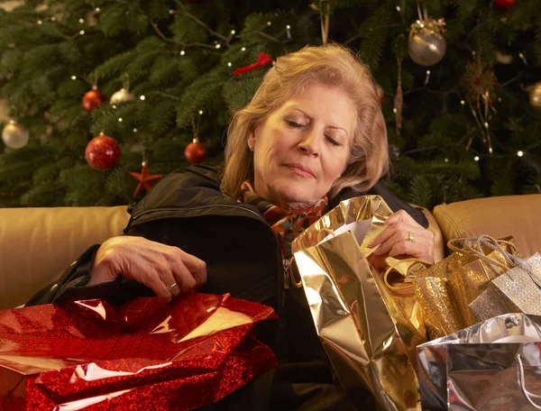 Уставшая пожилая женщина возвращается после рождественского похода по магазинам — стоковое фото