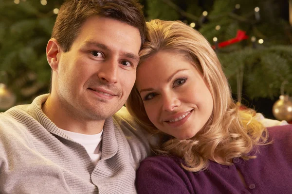 Paar ontspannende voor kerstboom — Stockfoto