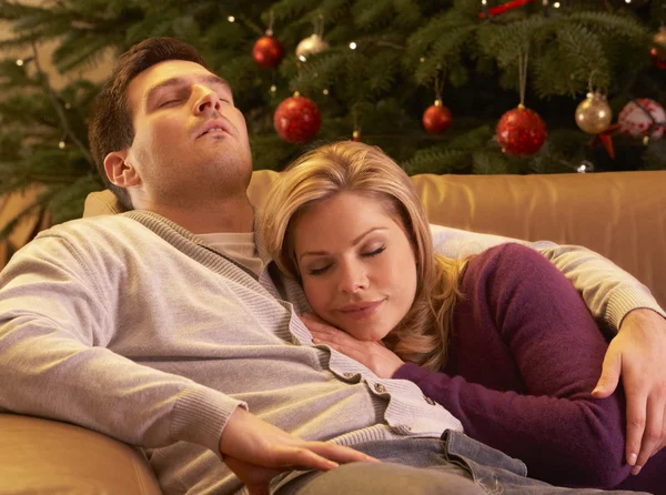 Casal cansado relaxando na frente da árvore de Natal — Fotografia de Stock