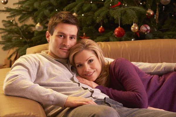 Casal relaxante na frente da árvore de Natal — Fotografia de Stock