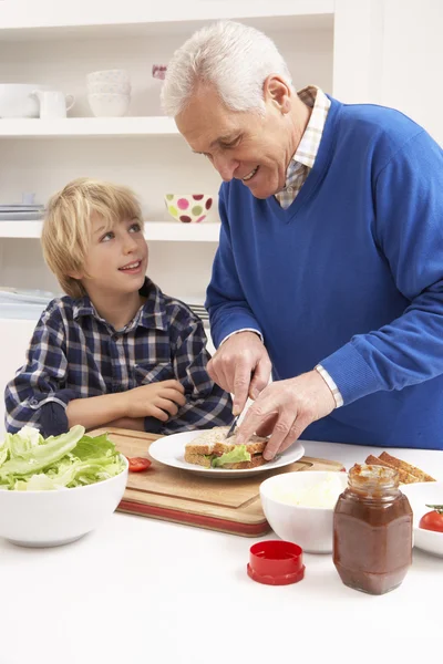 Grootvader en kleinzoon maken sandwich in keuken — Stockfoto