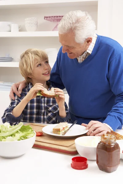 Grootvader en kleinzoon maken sandwich in keuken — Stockfoto