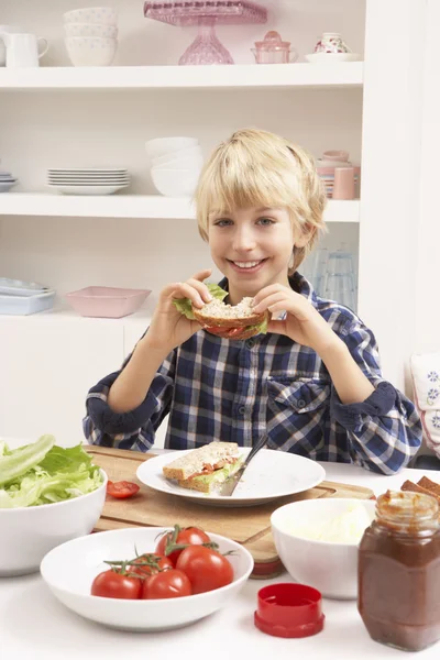Мальчик делает сэндвич на кухне — стоковое фото