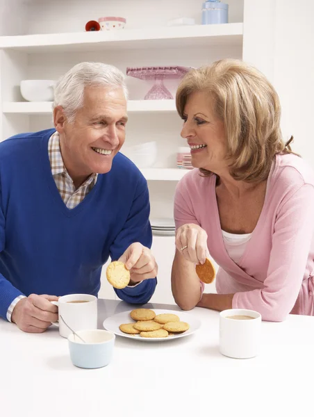 Äldre par njuter av varm dryck i köket — Stockfoto