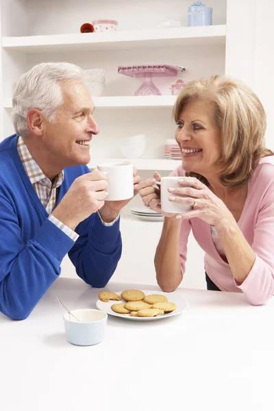 Senior koppel genieten van warme dranken in keuken — Stockfoto