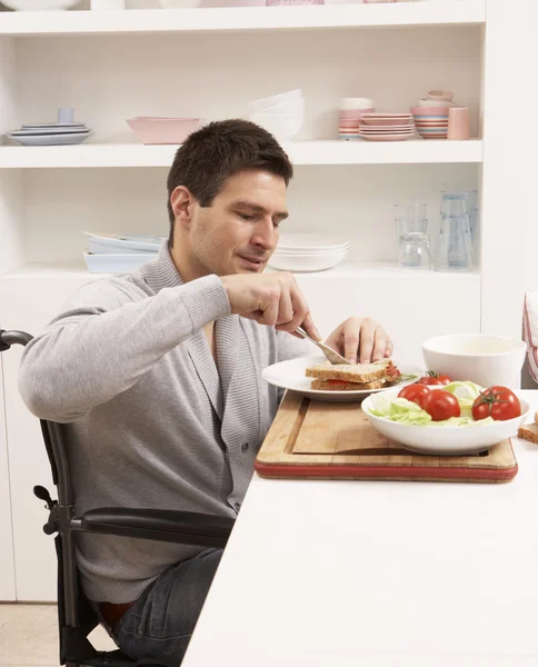 Инвалид делает сэндвич на кухне — стоковое фото