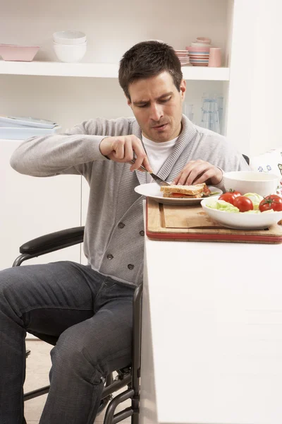 Людина з обмеженими можливостями робить сендвіч на кухні — стокове фото