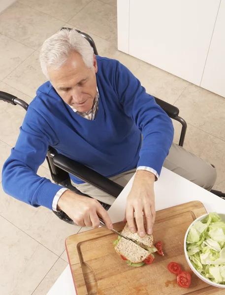 無効になっている年配の男性人の台所で作るサンドイッチ — ストック写真