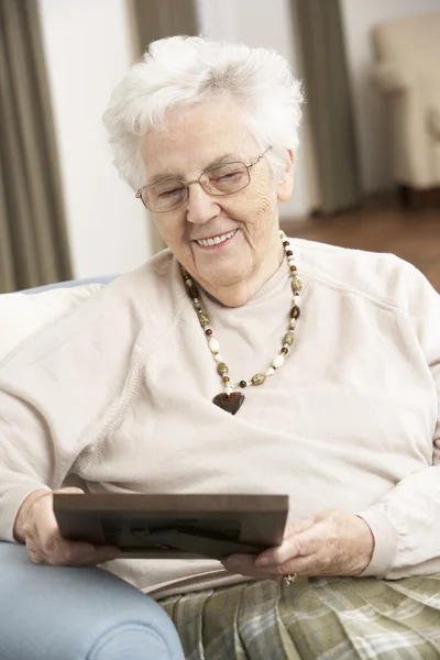 Ανώτερος γυναίκα κοιτάζοντας φωτογραφία σε πλαίσιο — Φωτογραφία Αρχείου