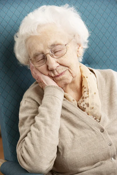 Starszy kobieta odpoczynku w fotelu w domu — Zdjęcie stockowe
