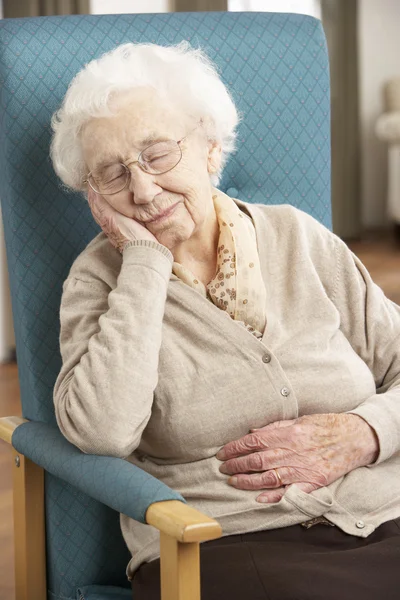 Äldre kvinna vilar i stolen hemma — Stockfoto