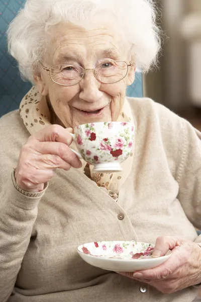 Äldre kvinna njuta kopp te hemma — Stockfoto