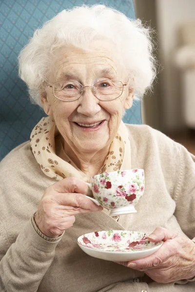 Mulher sênior desfrutando de xícara de chá em casa — Fotografia de Stock