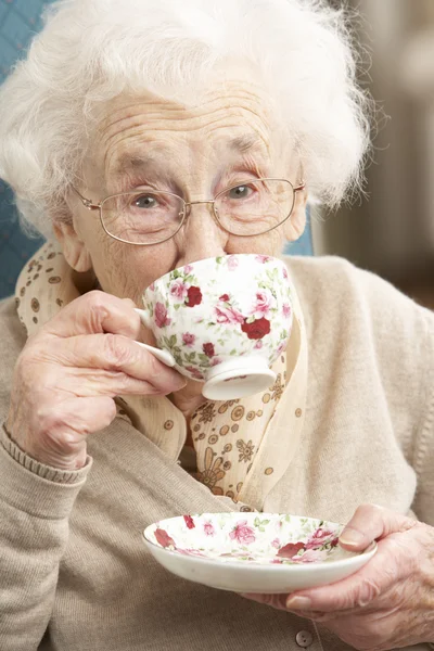 Senior vrouw genieten van kopje thee thuis — Stockfoto