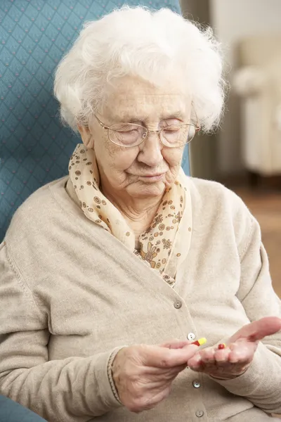 Mylić starszy kobieta patrząc na leki — Zdjęcie stockowe