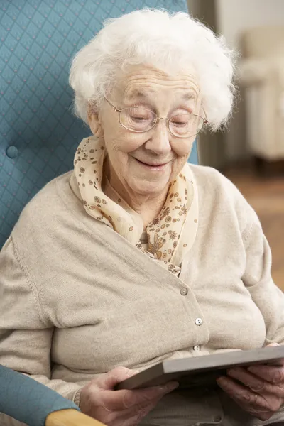 Mujer mayor mirando la fotografía en el marco —  Fotos de Stock