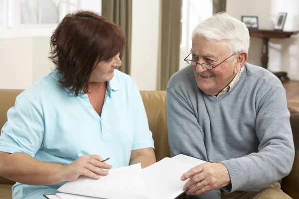 Senior man in discussie met gezondheid bezoeker thuis — Stockfoto