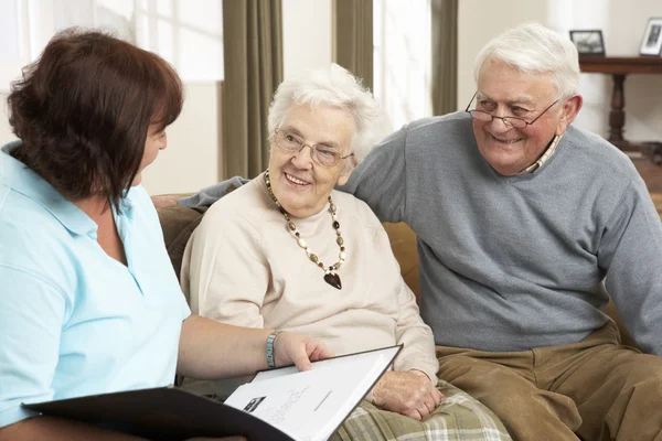 Senior koppel in discussie met gezondheid bezoeker thuis — Stockfoto