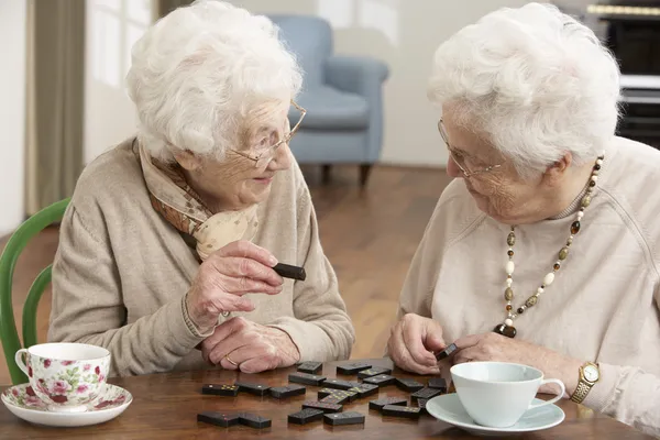 Dvě starší ženy hrají domino na denní stacionář — Stock fotografie