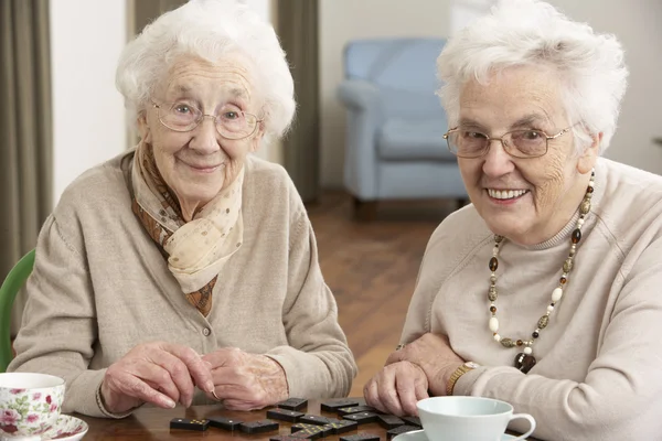 Dwóch starszych kobiet gra Domino w centrum opieki dziennej — Zdjęcie stockowe