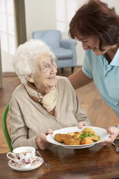 Senior mulher sendo servido refeição por cuidador — Fotografia de Stock
