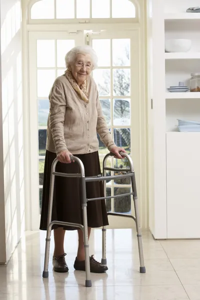 Oudere senior vrouw met behulp van wandelen frame — Stockfoto