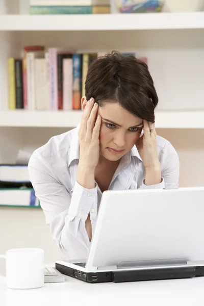 Preocupado buscando mujer que trabaja desde el hogar usando el ordenador portátil — Foto de Stock