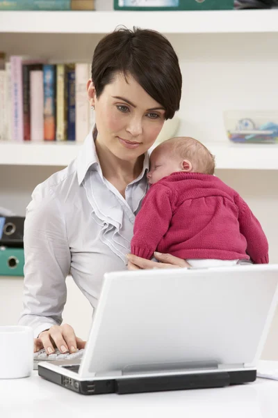Mujer con bebé recién nacido que trabaja desde el hogar usando el ordenador portátil —  Fotos de Stock