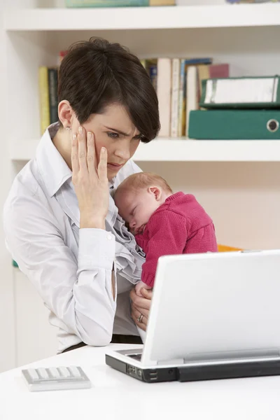 Mulher estressada com bebê recém-nascido trabalhando em casa usando laptop — Fotografia de Stock